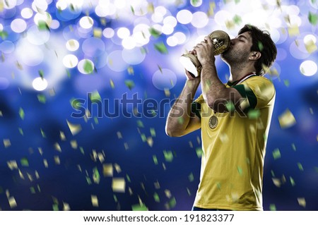 Brazilian soccer player, celebrating the championship with a trophy in his hand, on a blue background.