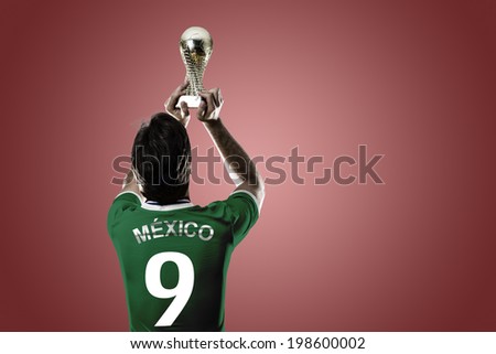 Mexican soccer player, celebrating the championship with a trophy in his hand. On a red background.