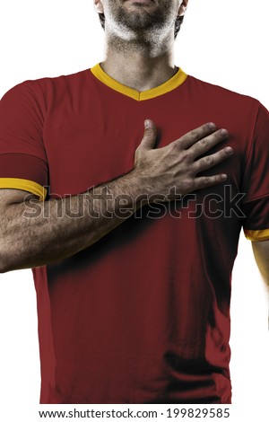 Spanish soccer player, listening to the national anthem with his hand on his chest. On a white background.