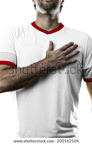 American soccer player, listening to the national anthem with his hand on his chest. On a white background.
