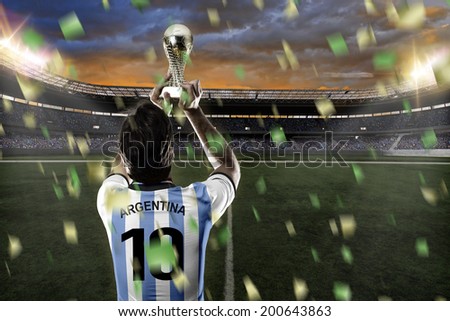 Argentinian soccer player, celebrating the championship with a trophy in his hand. On a stadium.
