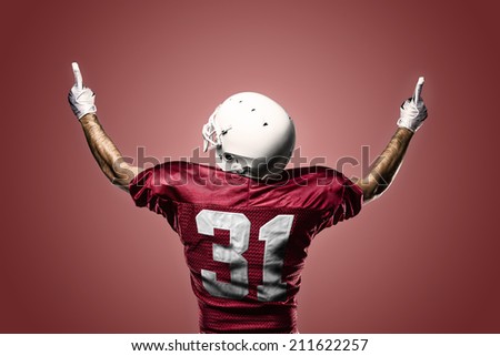Football Player on a Red uniform celebrating on a red background.