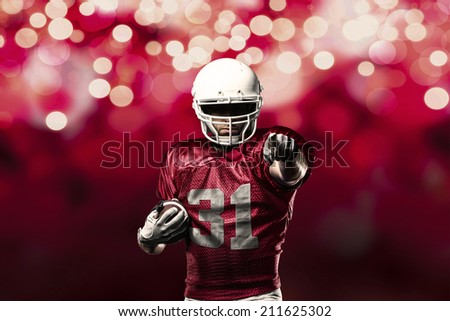 Football Player on a Red uniform celebrating on a red lights background.