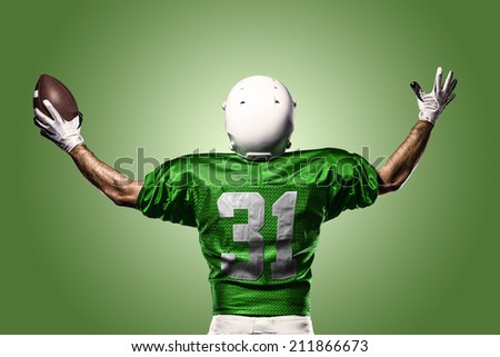 Football Player on a Green uniform celebrating on a Green background.