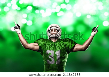 Football Player on a Green uniform celebrating on a Green lights background.