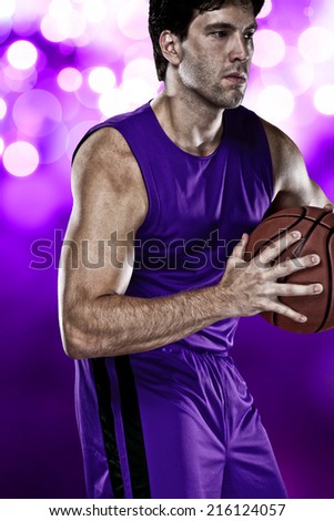 Basketball player on a  purple uniform, on a purple lights background.