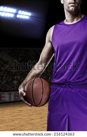 Basketball player on a  purple uniform, on a basketball court.