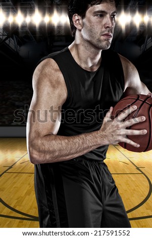 Basketball player on a  black uniform, on a basketball court.