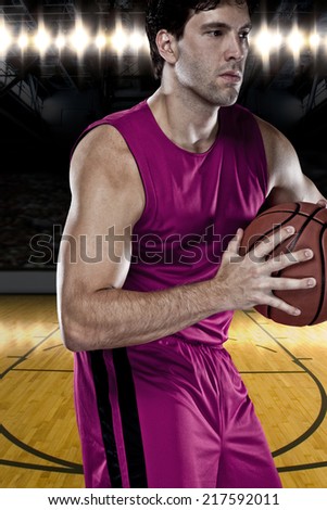 Basketball player on a  pink uniform, on a basketball court.