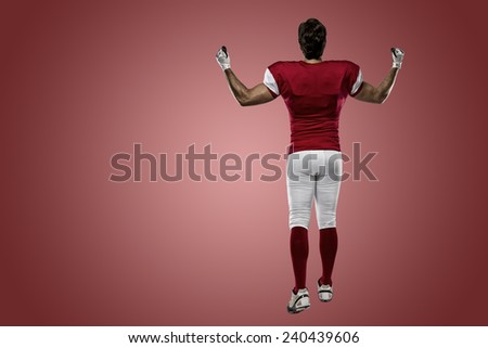 Football Player with a red uniform walking, showing his back on a red background.
