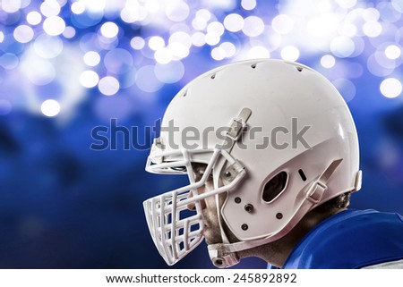 Close up of a Football Player with a blue uniform on a blue lights background.