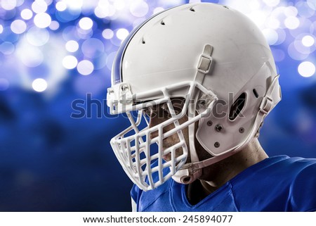 Close up of a Football Player with a blue uniform on a blue lights background.