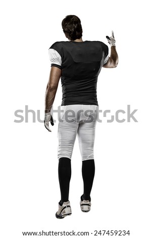 Football Player with a black uniform walking, showing his back on a white background.