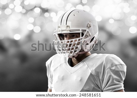 Close up of a Football Player with a white uniform on a white lights background.