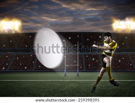 Rugby player in a yellow uniform kicking a ball on a stadium.