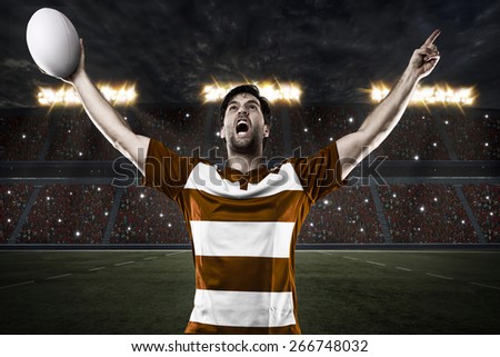 Rugby player in a orange uniform celebrating on a stadium.