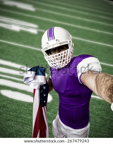 Football Player with a purple uniform making a selfie on a football field.