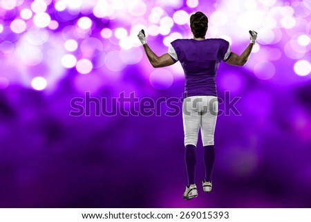 Football Player with a purple uniform walking, showing his back on a purple lights background.