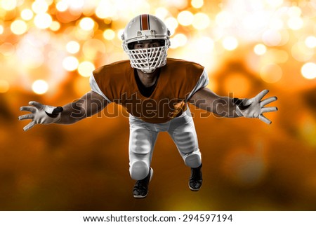 Football Player with a orange uniform making a tackle on a orange lights background.