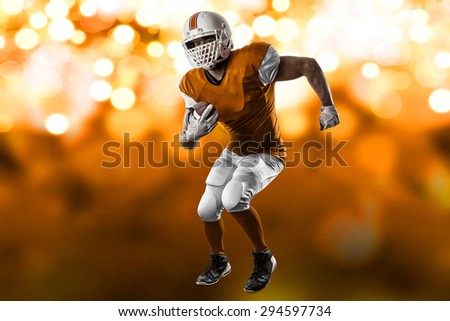 Football Player with a orange uniform Running on a orange lights background.