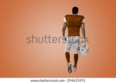 Football Player with a orange uniform walking, showing his back on a orange background.