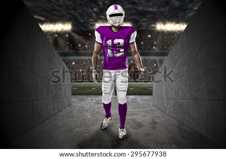 Football Player with a pink uniform entering a stadium tunnel.