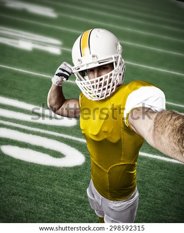 Football Player with a yellow uniform making a selfie on a football field.