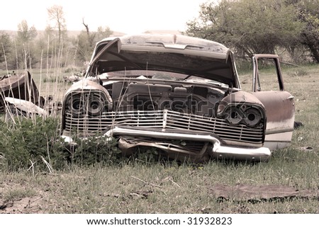 stock photo An old abandoned car in the middle of a field