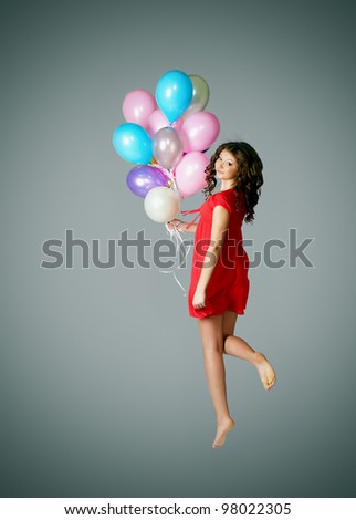 Portrait of an attractive young woman jumping with a balloons
