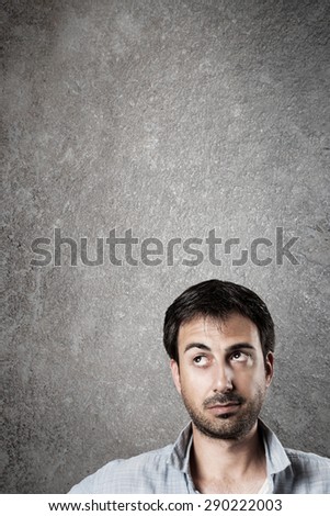 Man expectantly looking up with raised eyebrow. Vertical image.