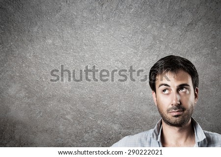Man expectantly looking up with raised eyebrow. Horizontal image.