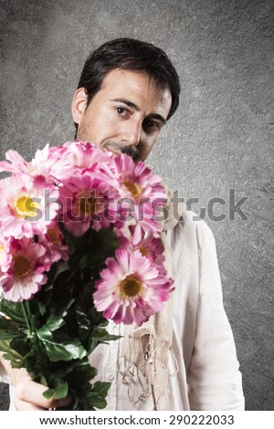 Man in love with a bouquet of pink flowers. Vertical image.