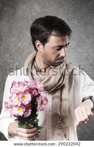 Man in love with a bouquet of flowers looking watch with concern. Vertical image.