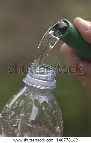 Filling a bottle with water with a hose
