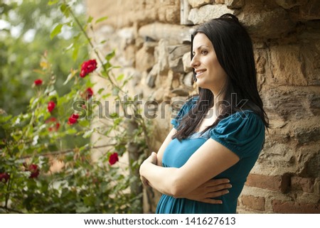 Beautiful mediterranean woman enjoying her old backyard
