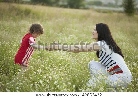 Mother and Daughter playing in a meadow