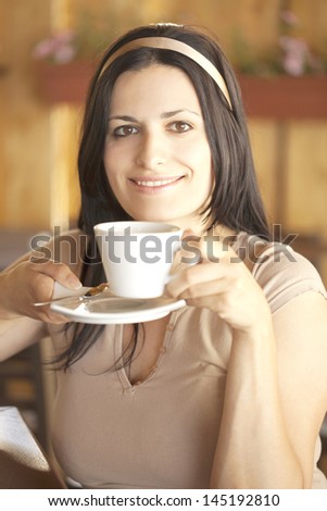 Portrait of a beautiful girl with a ribbon drinking coffee
