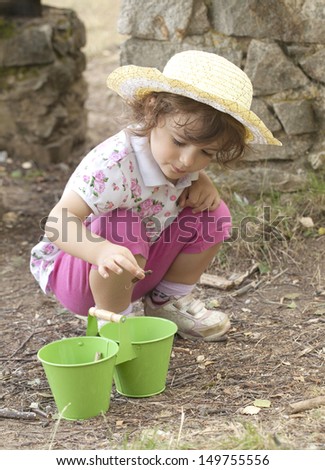 Little girl is helping out around the garden