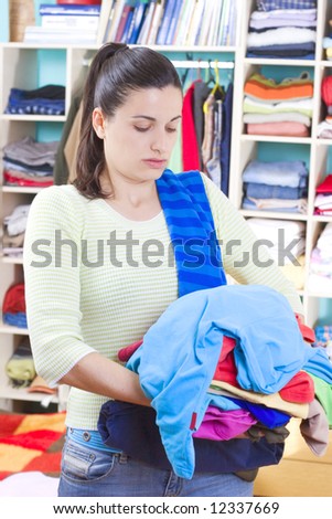 housewife putting clothes on available space, hanger, shelves