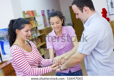 three friends or students putting hands together