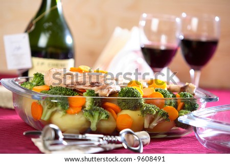 Hot vegetable dish with bottle of wine