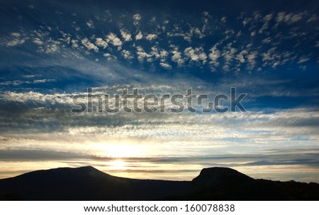 Majestic sunrise in mountains, morning sky with clouds, above dark landscape . Crimea, Ukraine
