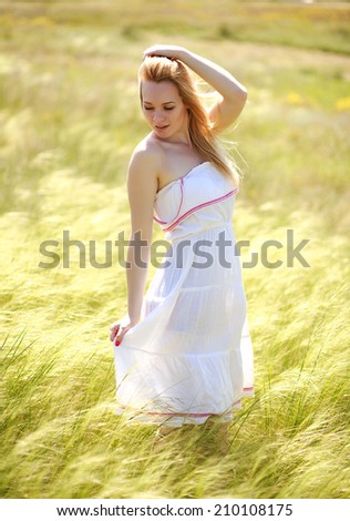 Happy cute girl enjoying a sunny summer day on a flowering meadow