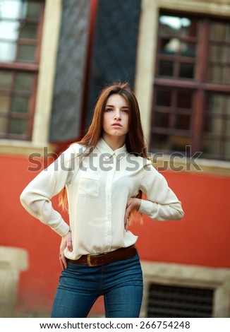Attractive young girl posing on street of the old city summer day