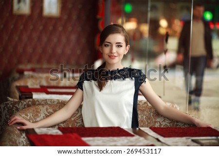 Beautiful young woman alone waiting at a table in a restaurant