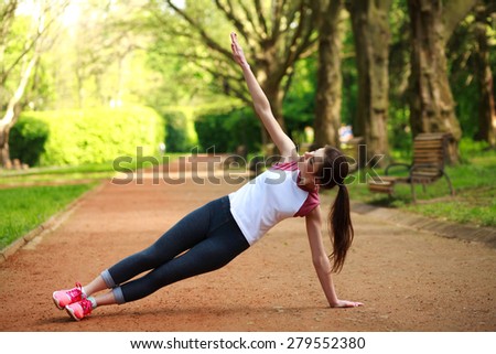 Sportive girl exercising outdoor in summer park, fitness training outdoors