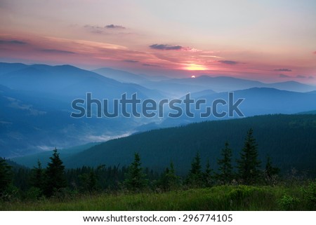 Dawn sun rise early in the morning in a mountain valley on a background of green forest