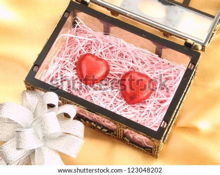 heart shape chocolates in treasure box isolated on gold background