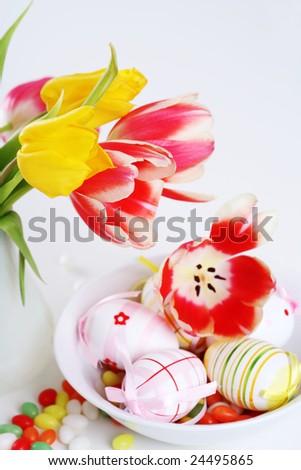 Home appliance - beautiful tulips in vase on the table with small Easter eggs