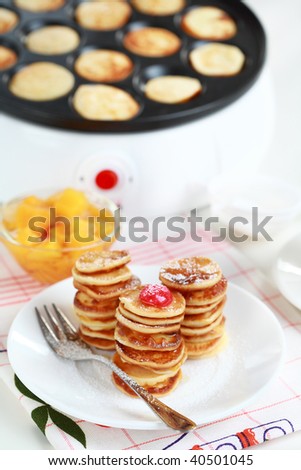 Sweet pancakes with  compote and pancake maker background